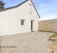 A family house in Dolný Bar with a white facade and a gravel yard.