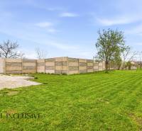 The garden of a family house in Dolný Bar with a lawn and a concrete fence.