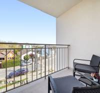 A balcony with seating and a view of the streets of a 4-room apartment in Dunajská Streda.
