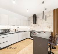 A kitchen with white cabinets, an island, and wood-patterned flooring in a 4-room apartment.