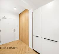Entrance hallway in a 4-room apartment with wood-patterned flooring and built-in wardrobes.
