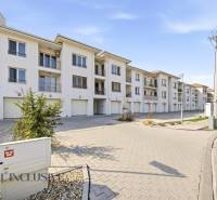 A set of white buildings and parking spaces in Dunajská Streda, ideal for a 4-room apartment.