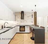 A kitchen with a counter and a wooden decor floor in a 4-room apartment.
