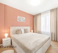 A bedroom with an orange wall and a wooden decor floor in a 4-room apartment.