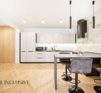 A kitchen in a 4-room apartment with a wooden decor floor and stylish lighting fixtures.