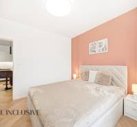 A bedroom in a 4-room apartment with a wood-decor floor and warm tones.