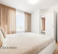 A bright bedroom in a 4-room apartment with a white wardrobe and curtains.