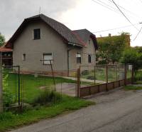A family house on Blatnica Street in the town of Blatnica with a simple garden and a metal fence.