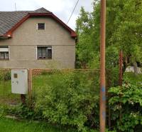 A family house in Blatnica on Blatnica Street surrounded by greenery and a fence.