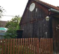 A wooden family house on Blatnica Street in Blatnica with a satellite dish and a lamp.