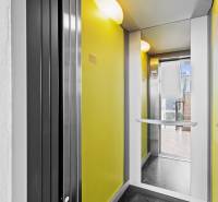 Yellow walls and glass doors of the elevator on M. R. Štefánik Street in Most pri Bratislave.