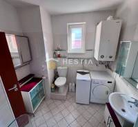 The bathroom includes a washing machine, cabinets, a toilet, and a sink, suitable for a studio apartment.