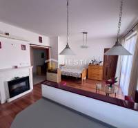 1-bedroom apartment with a fireplace, pendant lights, and wooden furniture, ideal for rent.