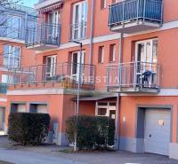 The image captures the exterior of an apartment building with balconies and garages in a one-room apartment.
