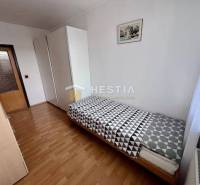 A room in a 2-room apartment with a bed, a wardrobe, and a floor with a wood decor.