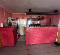 Gastro premises with a brick bar, wooden decor flooring, walls with pink paint.