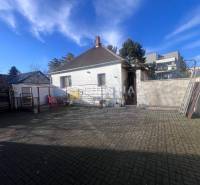 Courtyard exterior with concrete paving and a family house in the town of Senica, presented as gastro premises.