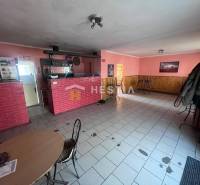 Interior of a gastro space with a red brick counter and pink walls.