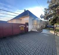 Family house with a garden in Senica, large entrance gate, paved courtyard, tree.