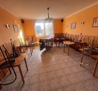 Gastro premises with tiles, chairs on tables, orange walls, and a window to the courtyard.