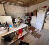 Kitchen with gastro spaces, white tiles, dispensers, kitchen utensils, fan, refrigerators.
