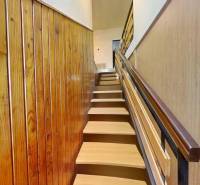 Wooden-decor stairs leading to the upper floor in a family house.