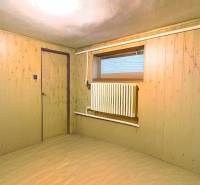 A room with a wooden floor decor, wooden walls, a radiator, interior of a family house.