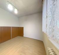 A room with wooden decor and a curtain in a family house.