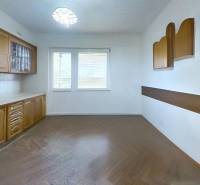 A kitchen in a family house with light cabinets and a wooden decor floor.