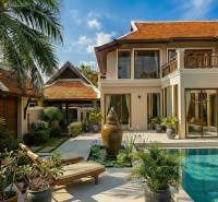 Villa in Pattaya with a pool, wooden decor, and a garden with palm trees and loungers.