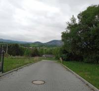 The road on Chotárna Street in Žilina surrounded by greenery, suitable for residential plots.