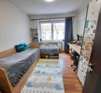 Children's room with a bed, desk, and floor with wooden decor in a 3-room apartment.