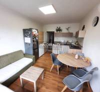 Living room with kitchen, wooden decor flooring, 3-room apartment, dining table and chairs.