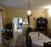Dining room in a family house with wooden furniture, a television, and an entrance to another room.