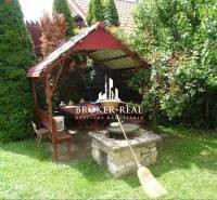 A gazebo with a table and benches in the garden by a family house in Goncruszka.