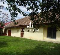 A family house in the town of Goncruszka with a garden and a traditional roof under a tree.