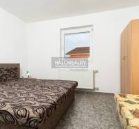 A room in a hotel or guesthouse with a unique bed pattern and a wall painting.