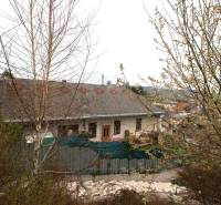 A soaked family house in Kostoľany nad Hornádom surrounded by greenery and shrubs.
