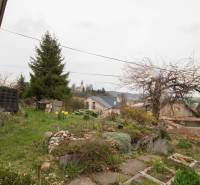 A family house in Kostoľany nad Hornádom with a garden, trees, and a view of the church.
