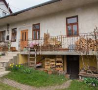 A family house in Kostoľany nad Hornádom, with wood on the terrace and a garden.