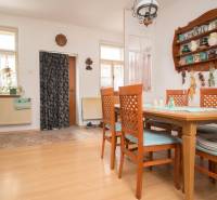 Dining room in a family house with a wooden decor floor and wooden furniture.