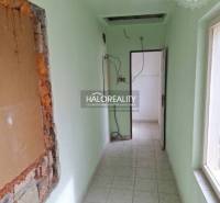 A narrow interior with light green walls and a tiled floor.