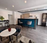 The interior of a family house with a bar counter, dining table, and comfortable chairs.