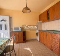 A family house kitchen with wooden decor and a sunny wall decoration.