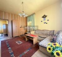Living room in a family house with a wooden decor floor and flowers.