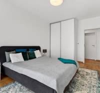 Bedroom in a 2-room apartment with a bed, nightstand, and wardrobe.