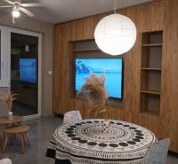 Living room in a two-room apartment with a wooden decor floor and a round table.