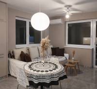 Living room with a sofa, round table, and decorative light fixture in a 2-room apartment.