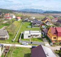 Family houses on Bošianska Street in Neporadza surrounded by greenery and mountains.