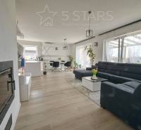 Living room in a family house with a large sofa and a wooden decor floor.